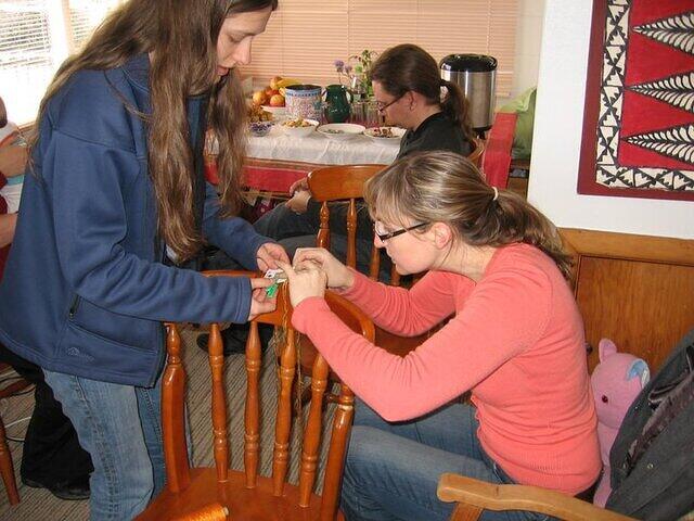 Amalie helping Marie set up her cards to begin weaving.